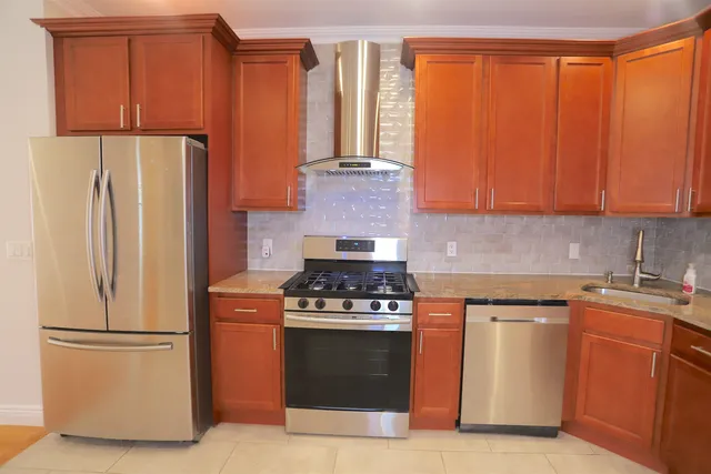 a kitchen with granite countertop a refrigerator stove and cabinets