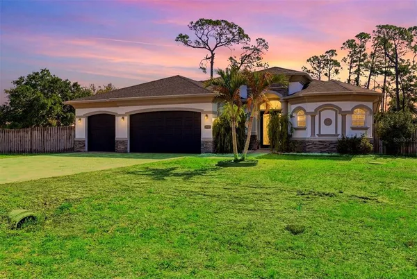 a front view of a house with a garden and yard