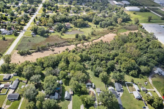 an aerial view of residential houses with outdoor space and trees