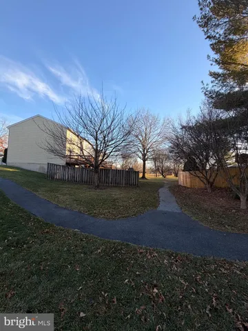 a view of dirt yard with large trees
