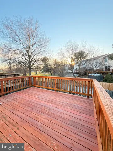 a view of deck with wooden floor and fence next to a yard
