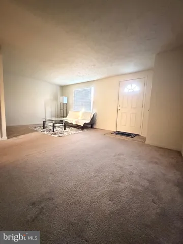 a view of empty room with kitchen