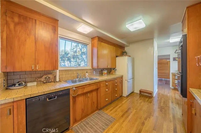 a kitchen with a sink a counter top space and stainless steel appliances