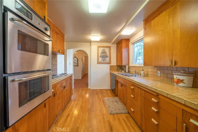 a large kitchen with stainless steel appliances granite countertop a large stove top oven and cabinets