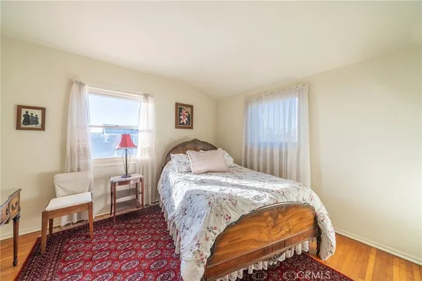 a bed sitting in a bedroom next to a window with chair