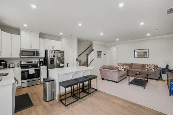 a living room with furniture and a dining table with kitchen view