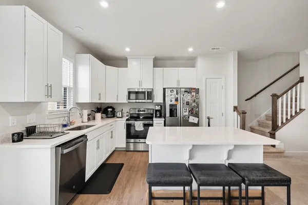 a kitchen with white cabinets and sink