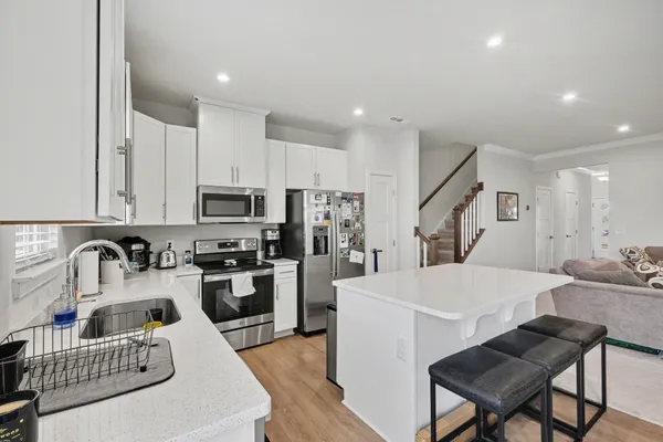 a kitchen with kitchen island a sink stove and refrigerator