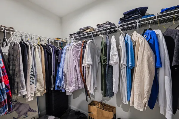a view of walk in closet with clothes