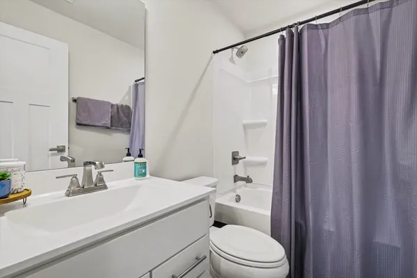 a bathroom with a sink a toilet and shower curtain
