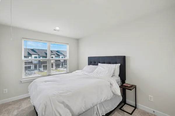 a large bed sitting in a bedroom next to a window