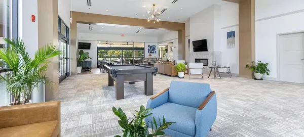 a living room with patio furniture and a potted plant