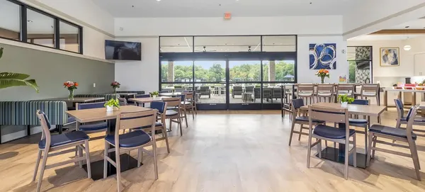 a dining room with stainless steel appliances a table and chairs in it