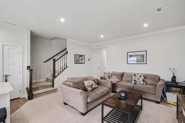a living room with furniture and a wooden floor
