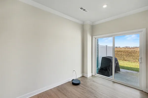 an empty room with wooden floor and a window