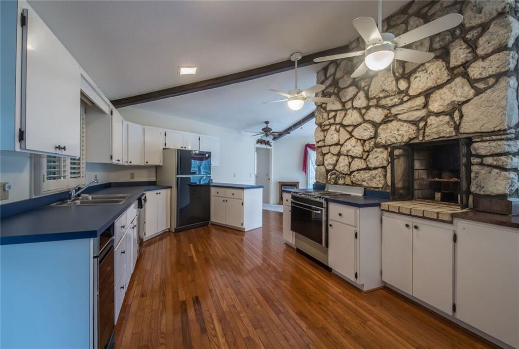 288 Rockledge Road Spruce Pine, NC 28777 - Photo 3 of 27 a kitchen with granite countertop a stove top oven a sink dishwasher and a refrigerator with wooden floor