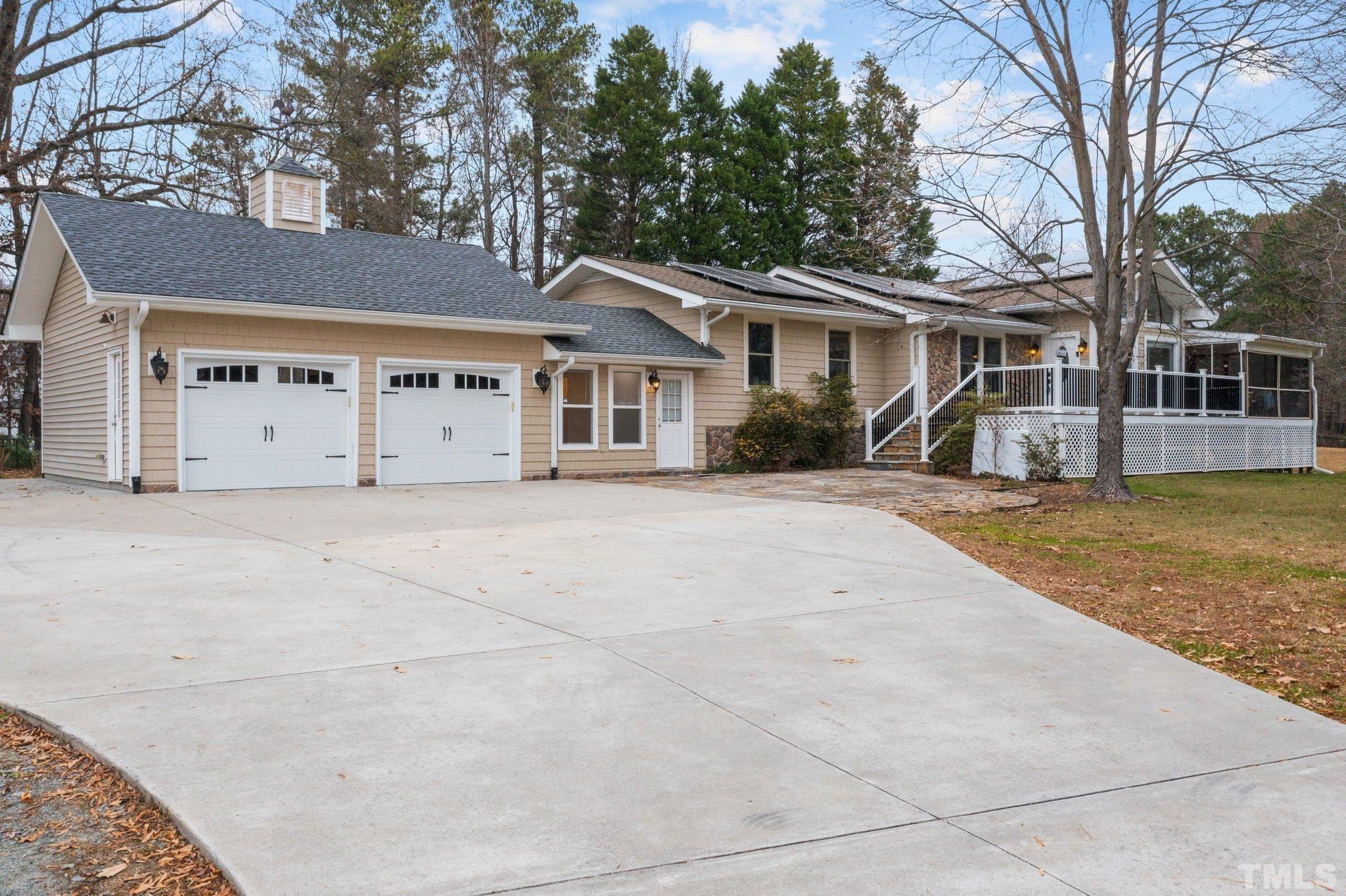 a front view of a house with a garden and trees