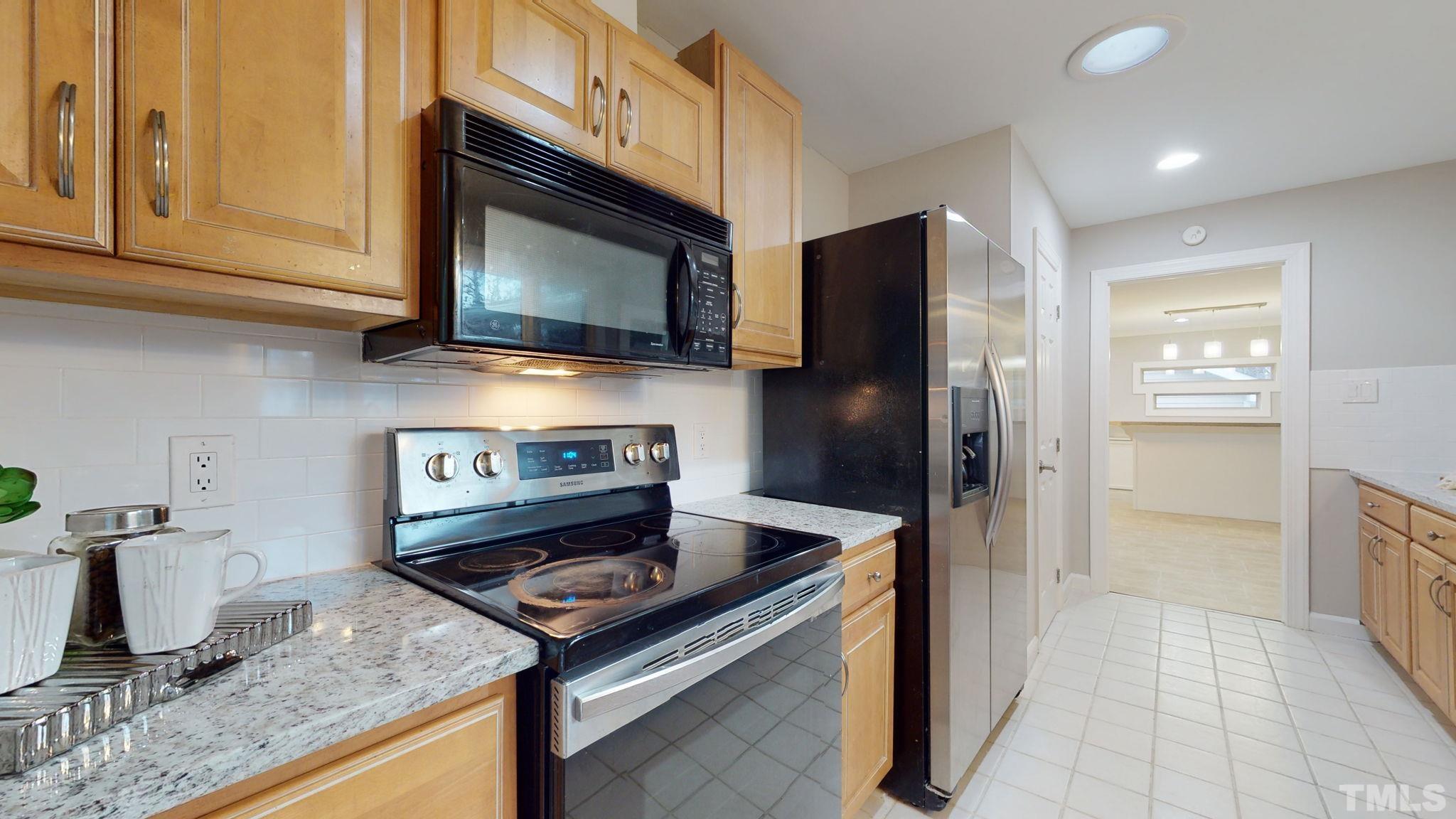 1613 Jenks Carpenter Road Cary, NC 27519 - Photo 29 of 60 a kitchen with granite countertop a stove and a microwave