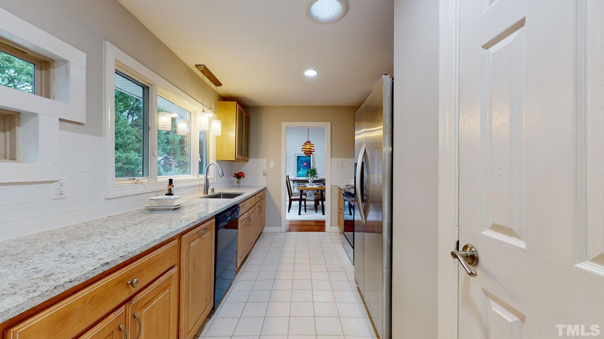 1613 Jenks Carpenter Road Cary, NC 27519 - Photo 33 of 60 a large kitchen with stainless steel appliances granite countertop a sink and large window