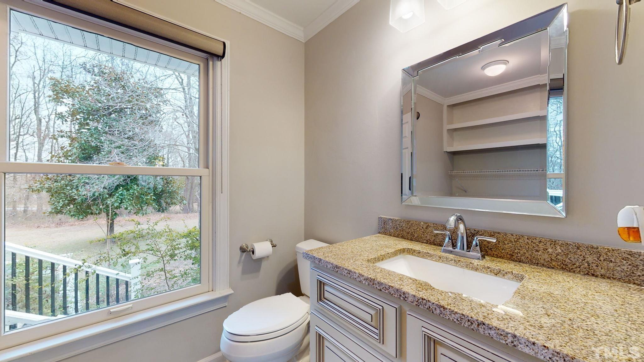 1613 Jenks Carpenter Road Cary, NC 27519 - Photo 38 of 60 a bathroom with a granite countertop sink toilet and mirror