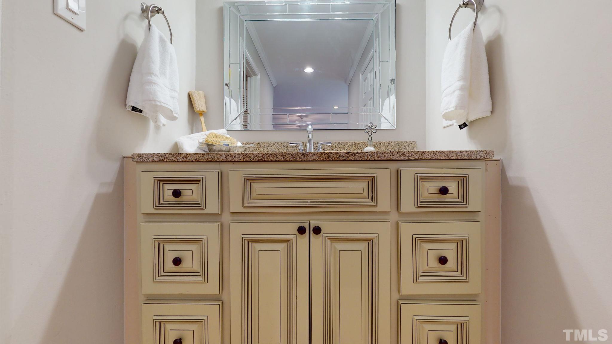 1613 Jenks Carpenter Road Cary, NC 27519 - Photo 56 of 60 a view of a hallway with granite countertop a sink and a mirror