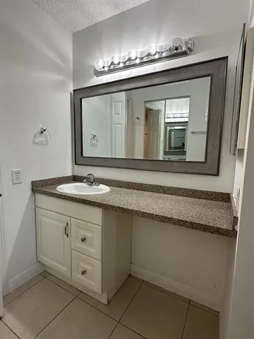 a spacious bathroom with a granite countertop sink a mirror and a