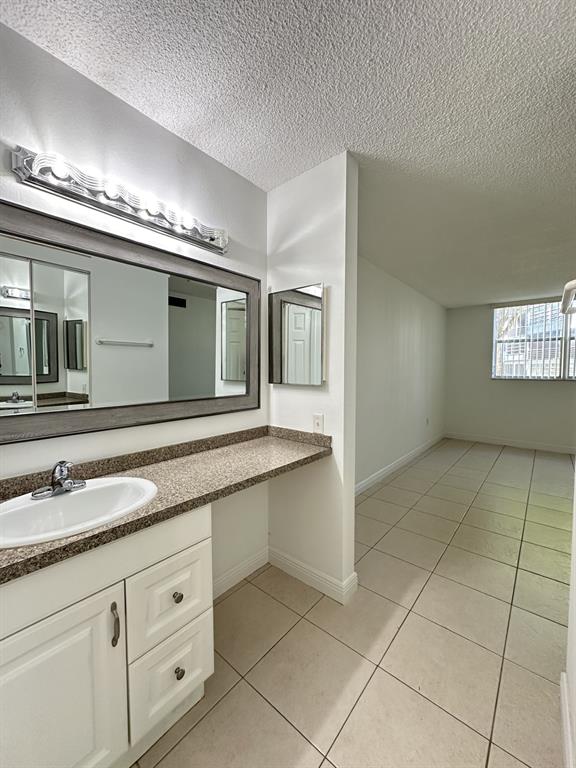 9401 Lime Bay Boulevard, Unit 115 Tamarac, FL 33321 - Photo 13 of 20 a spacious bathroom with a granite countertop sink a mirror and a