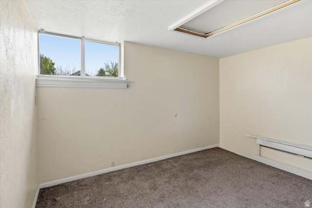 395 North 400 West Logan, UT 84321 - Photo 29 of 48 Carpeted interior space featuring a double-pane window with white trim, baseboard heating, and a ceiling light fixture opening