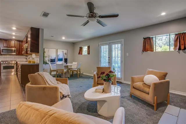 a living room with furniture kitchen view and a wooden floor