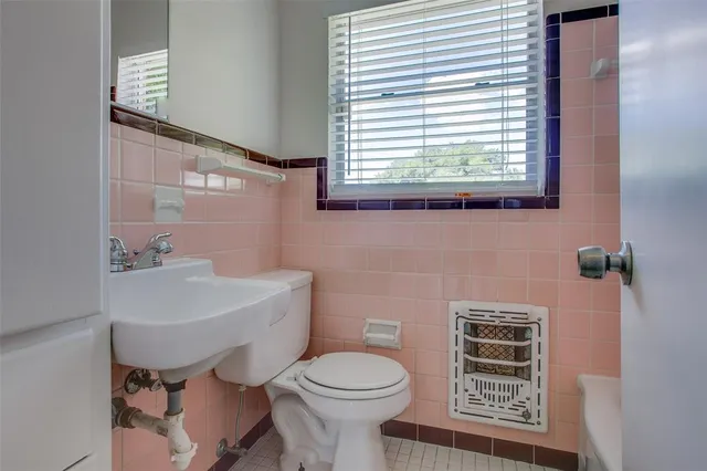 a bathroom with a toilet a sink and a window