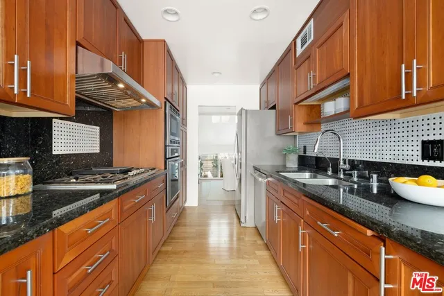 a kitchen with stainless steel appliances granite countertop a sink stove and refrigerator