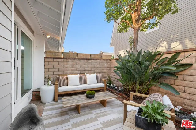 a view of a patio with couches table and chairs and potted plants