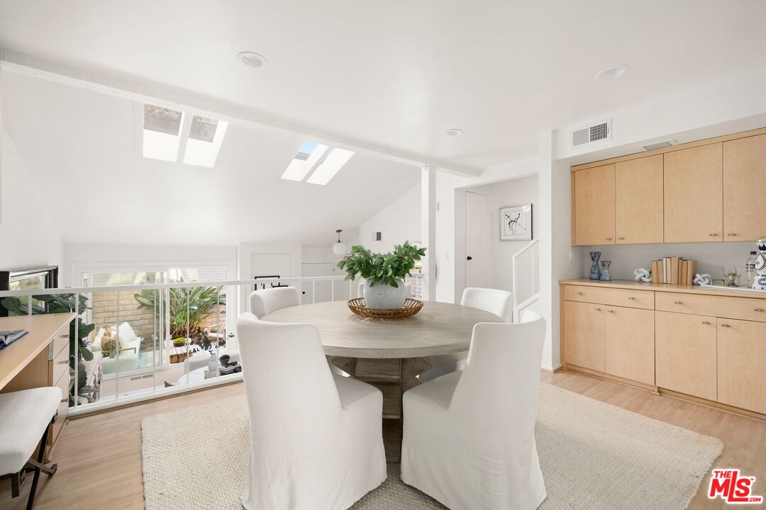 13010 Maxella Avenue, Unit 5 Marina del Rey, CA 90292 - Photo 7 of 32 a kitchen with stainless steel appliances kitchen island granite countertop a table and chairs in it