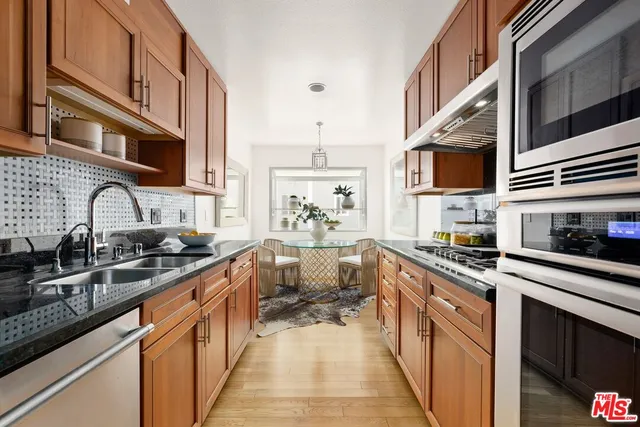 a kitchen with stainless steel appliances a sink stove top oven and cabinets