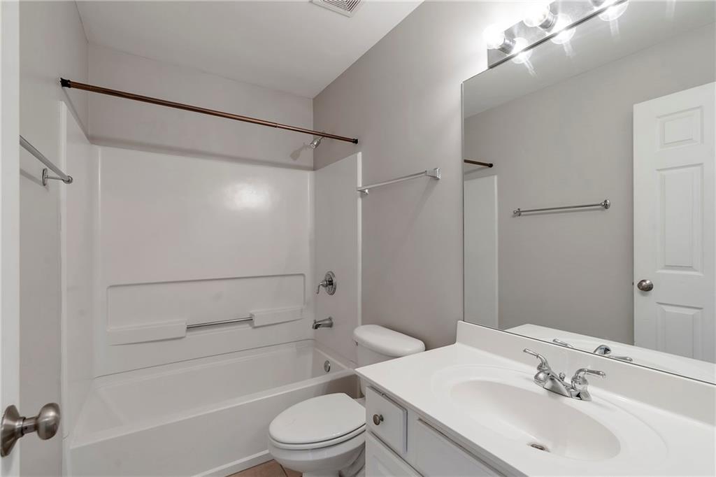 1653 Fair Oak Way Mableton, GA 30126 - Photo 22 of 30 a bathroom with a bathtub shower sink vanity mirror and toilet