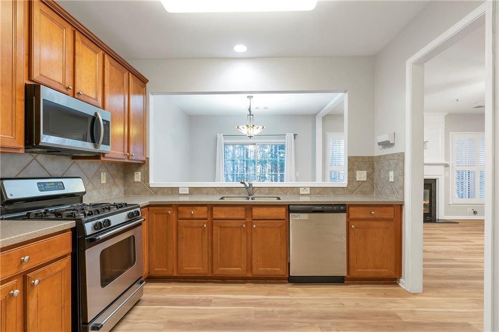 1653 Fair Oak Way Mableton, GA 30126 - Photo 8 of 30 a kitchen with stainless steel appliances granite countertop a stove a sink dishwasher and a microwave oven with wooden floor