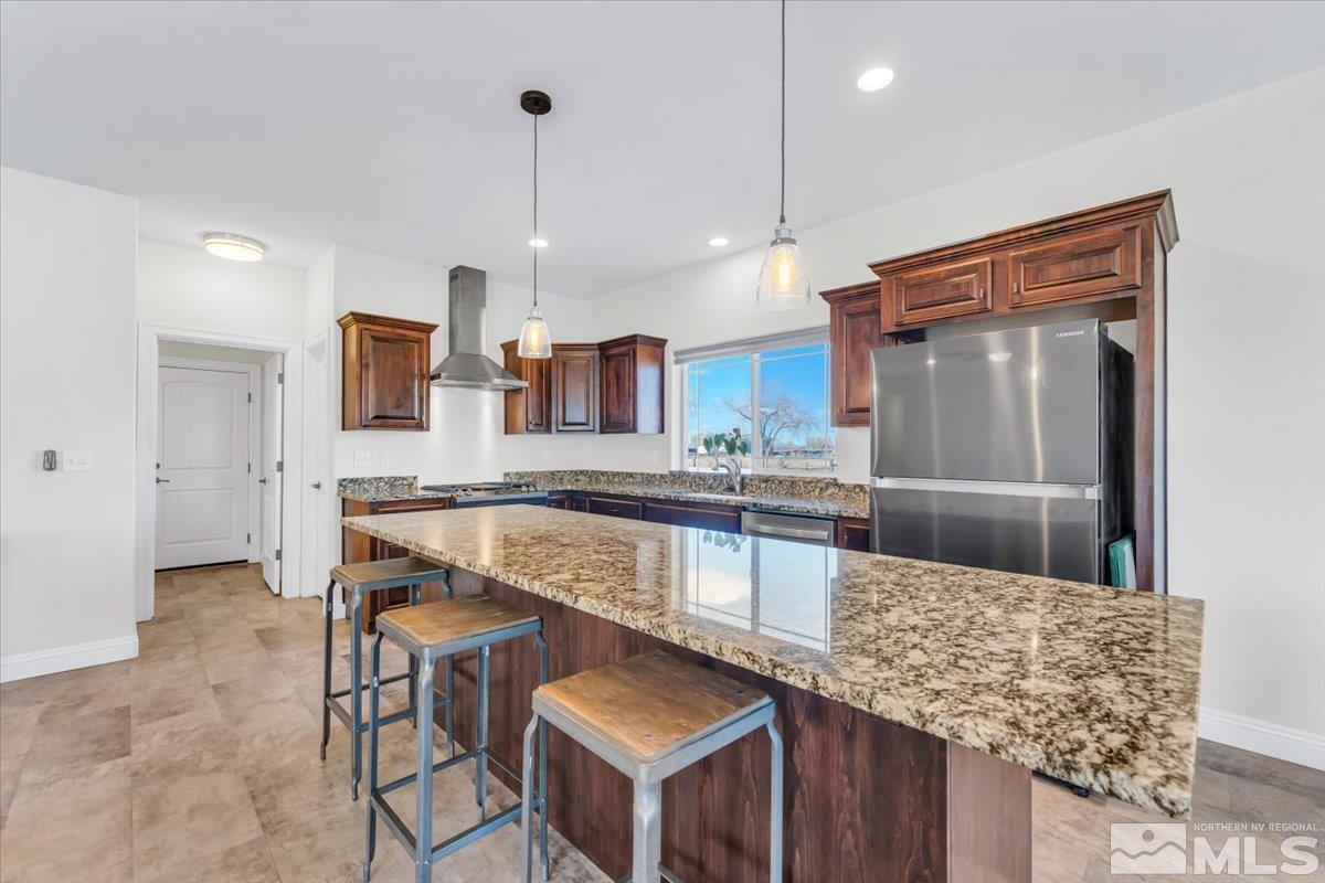 3071 Schindler Road Fallon, NV 89406 - Photo 12 of 40 a kitchen with stainless steel appliances kitchen island granite countertop a table chairs in it and wooden floors