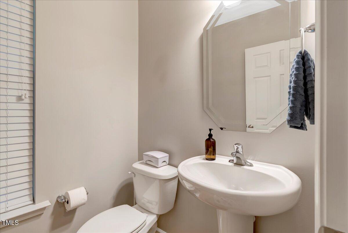 201 Forbes Road Wake Forest, NC 27587 - Photo 17 of 42 a bathroom with a sink a toilet and mirror