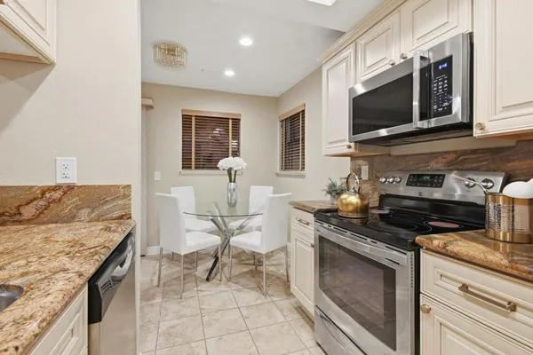 a kitchen with stainless steel appliances granite countertop a stove top oven microwave and cabinets