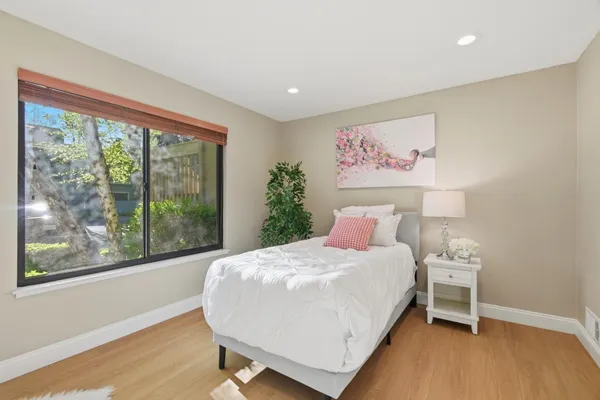 a bedroom with a bed and a large window