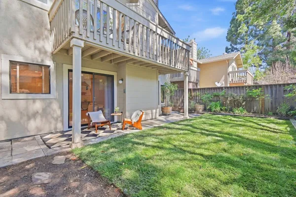 a view of a chair and table in backyard of the house
