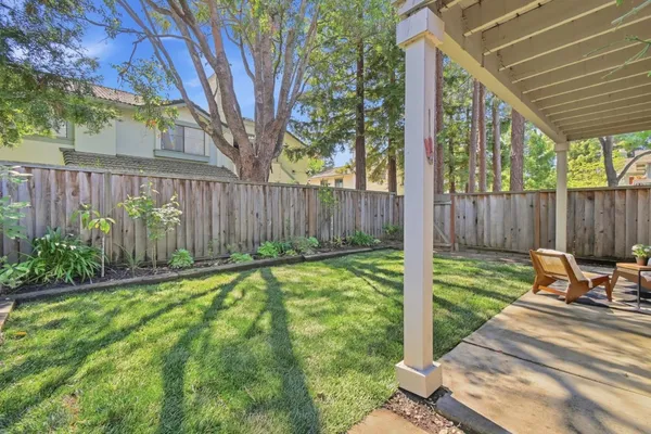 a view of a backyard with table and chairs and wooden fence
