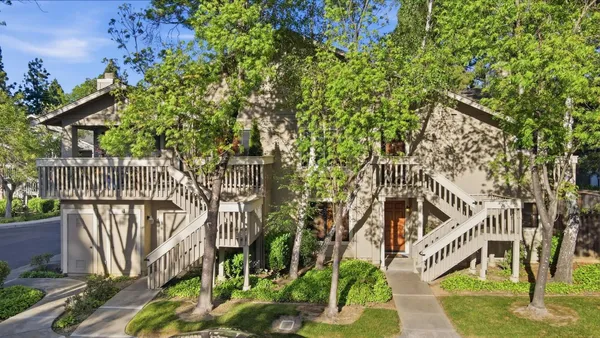 a view of a large yard with plants and wooden fence