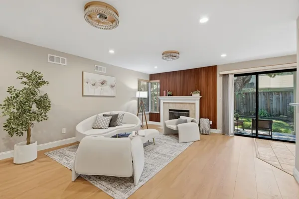 a living room with furniture a fireplace and a large window