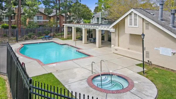 a backyard with table and chairs and potted plants