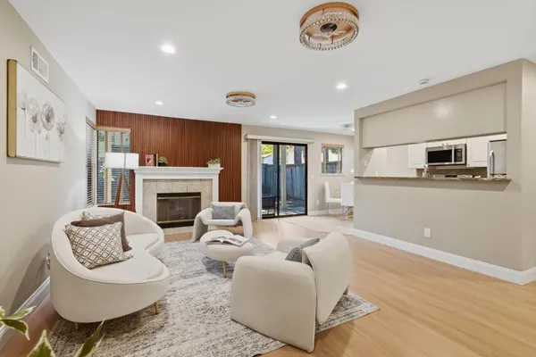 a living room with furniture a fireplace and kitchen view