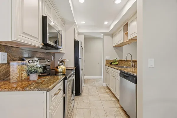 a kitchen with granite countertop a sink stove and cabinets