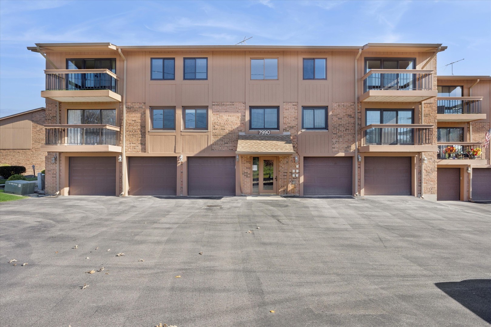7990 Garfield Avenue, Unit 143 Burr Ridge, IL 60527 - Photo 1 of 16 a front view of a building with a yard and parking space