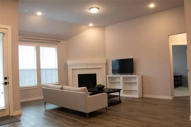 a living room with furniture a fireplace and a flat screen tv