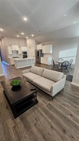 a living room with furniture and a wooden floor